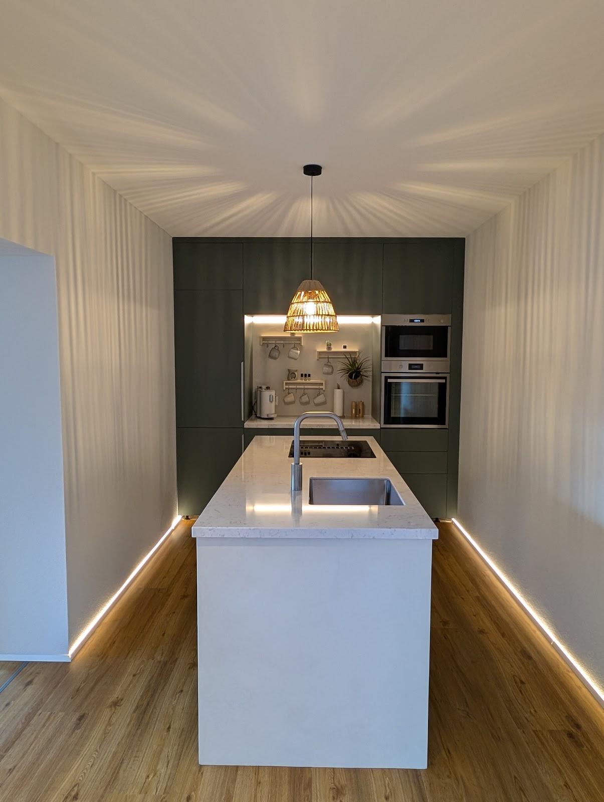 Küche der unteren Wohnung mit Kochinsel und Holzfussboden